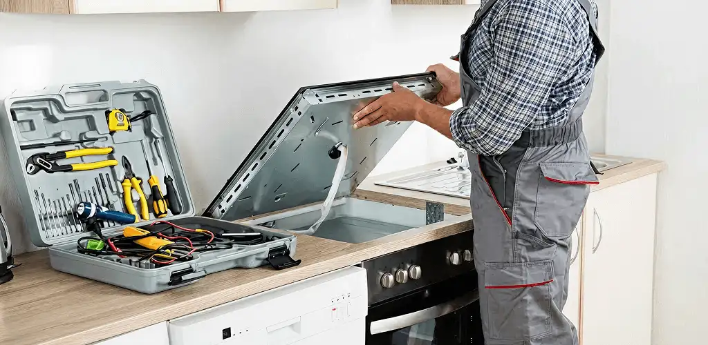 Handyman repairing a cooktop and checking wiring connections in Provo, UT