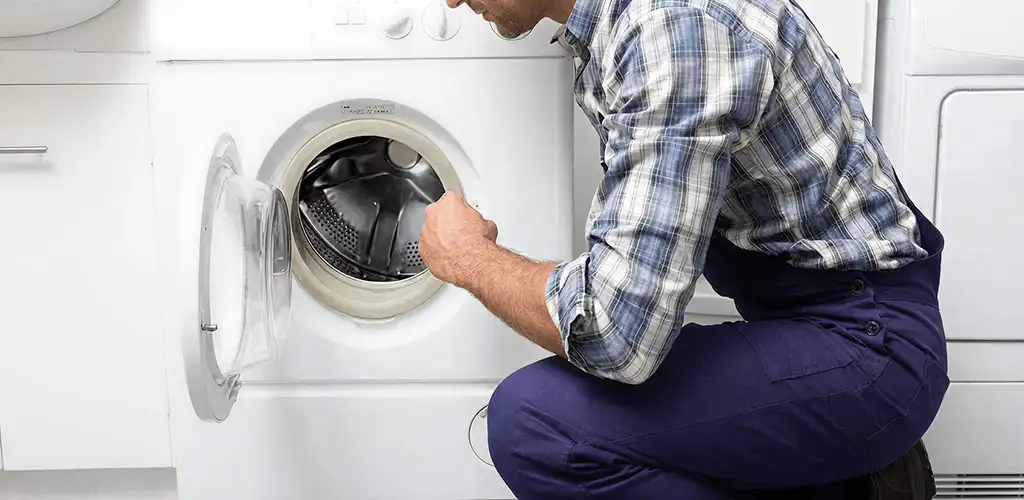 Handyman inspecting a dryer drum and internal parts for repair in Provo, UT