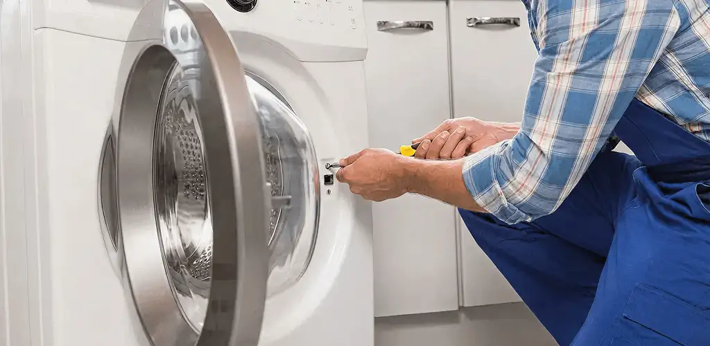 Handyman repairing a clothes dryer and checking electrical connections in Provo, UT