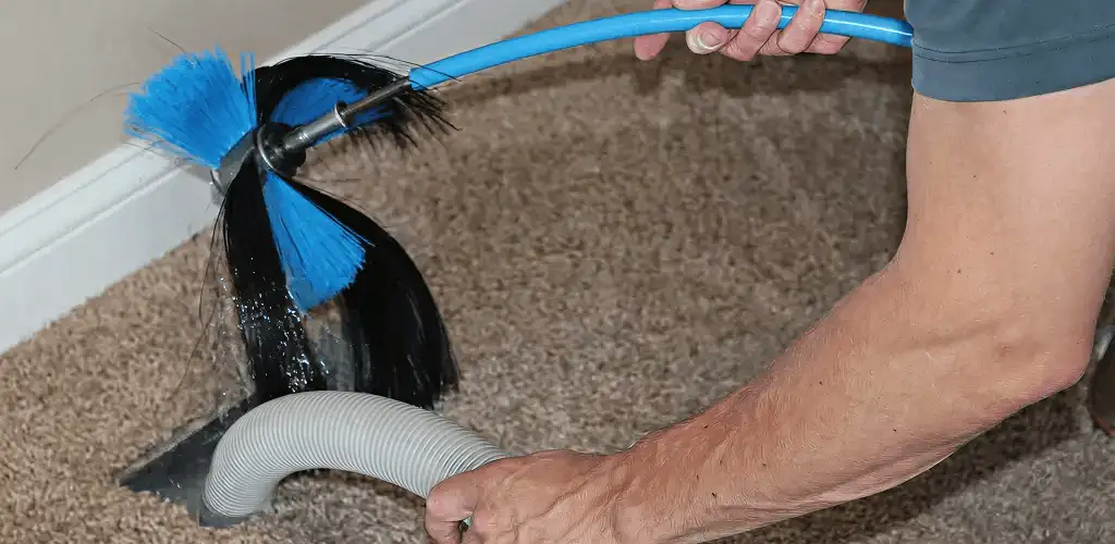 Dryer vent cleaning technician brushing lint from a vent line in Provo, UT