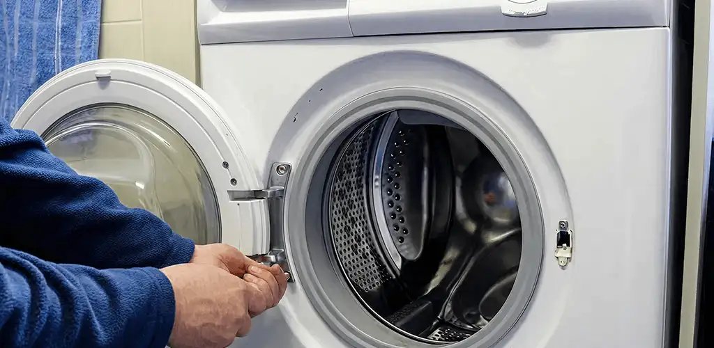 Washing machine repair handyman checking a front-load washer door and latch in Provo, UT
