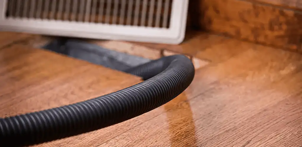 Air duct cleaning hose inserted into a floor vent for ductwork cleaning in Provo, UT