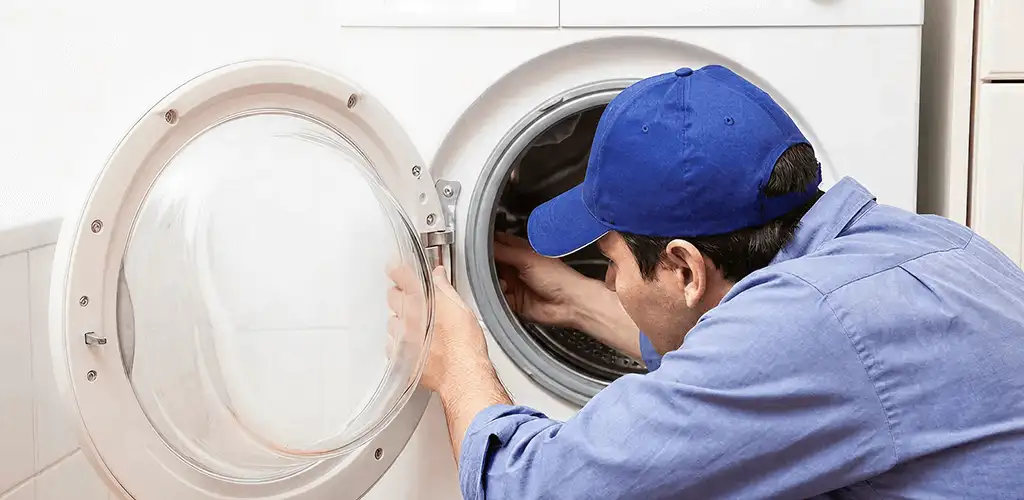 Washing machine repair handyman inspecting a front-load washer drum in Provo, UT